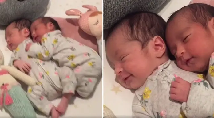 Tiny baby twins cuddle as they nap