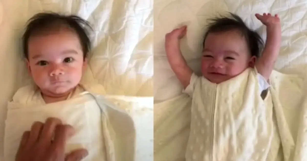 Baby throws his arms up for joy every morning when parents unswaddle him