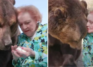 Actress Betty White, who turned 99 this year, gives a grizzly bear a kiss