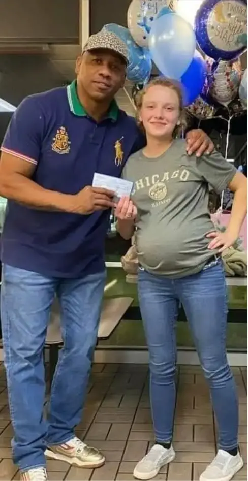 A pregnant waitress smiles as she receives a surprise gift at Waffle House.