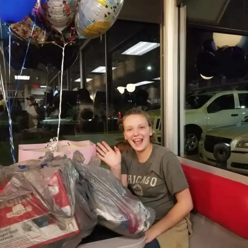 A pregnant waitress smiles as she receives a surprise gift at Waffle House.