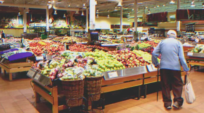 Boy helps old man with shaking hands pick up groceries from floor, man gives him tiny parcel